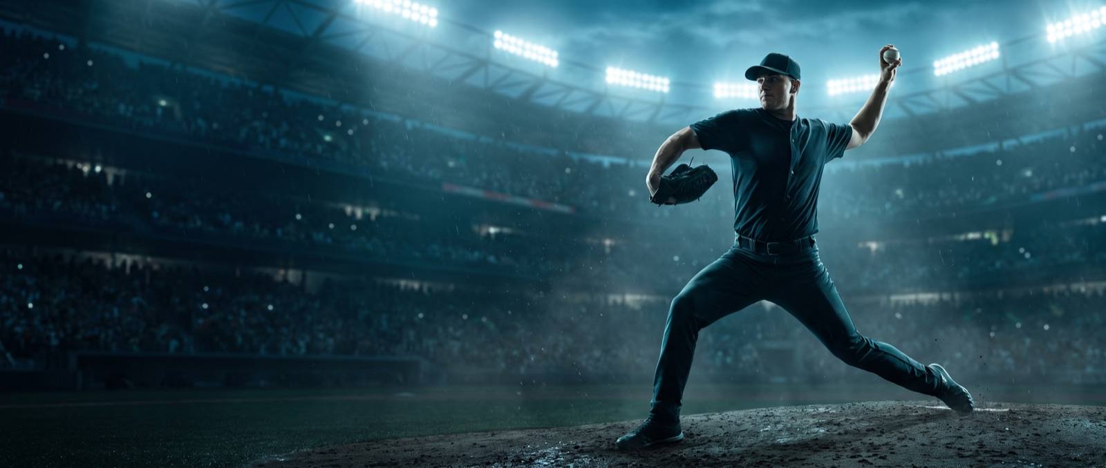 Pitcher mid delivery during a night bullpen session